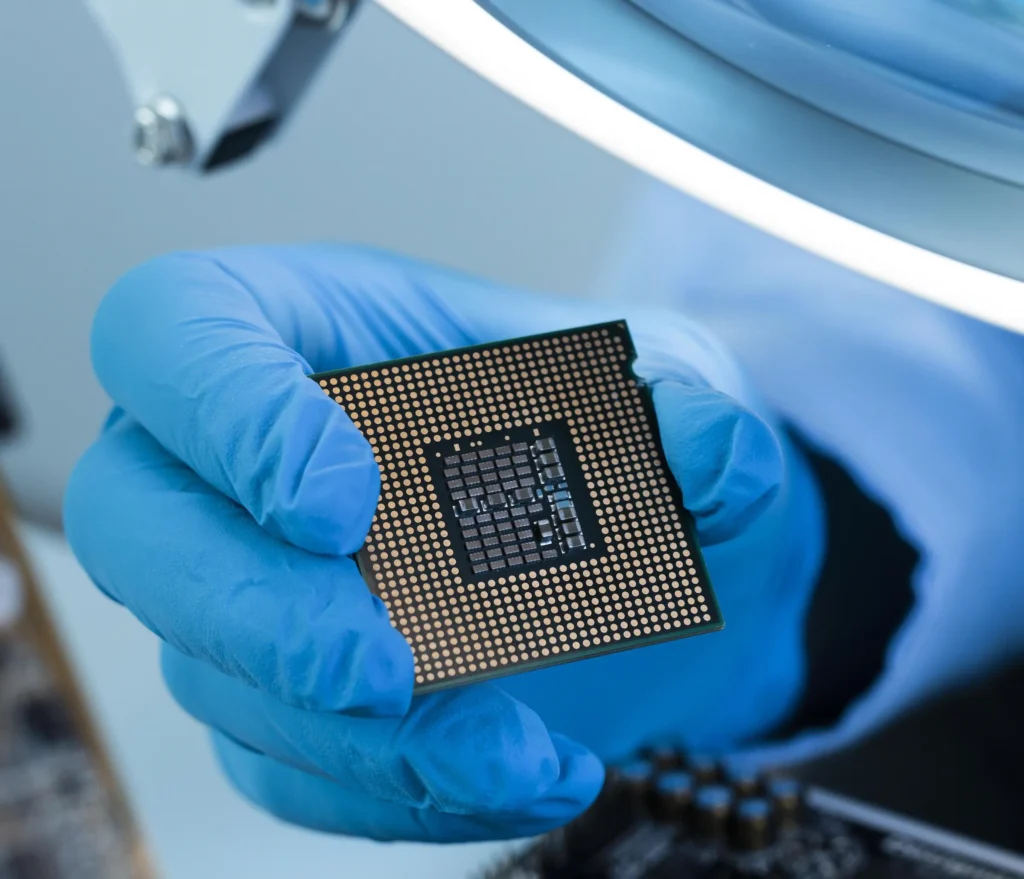 A gloved hand holding a microchip 