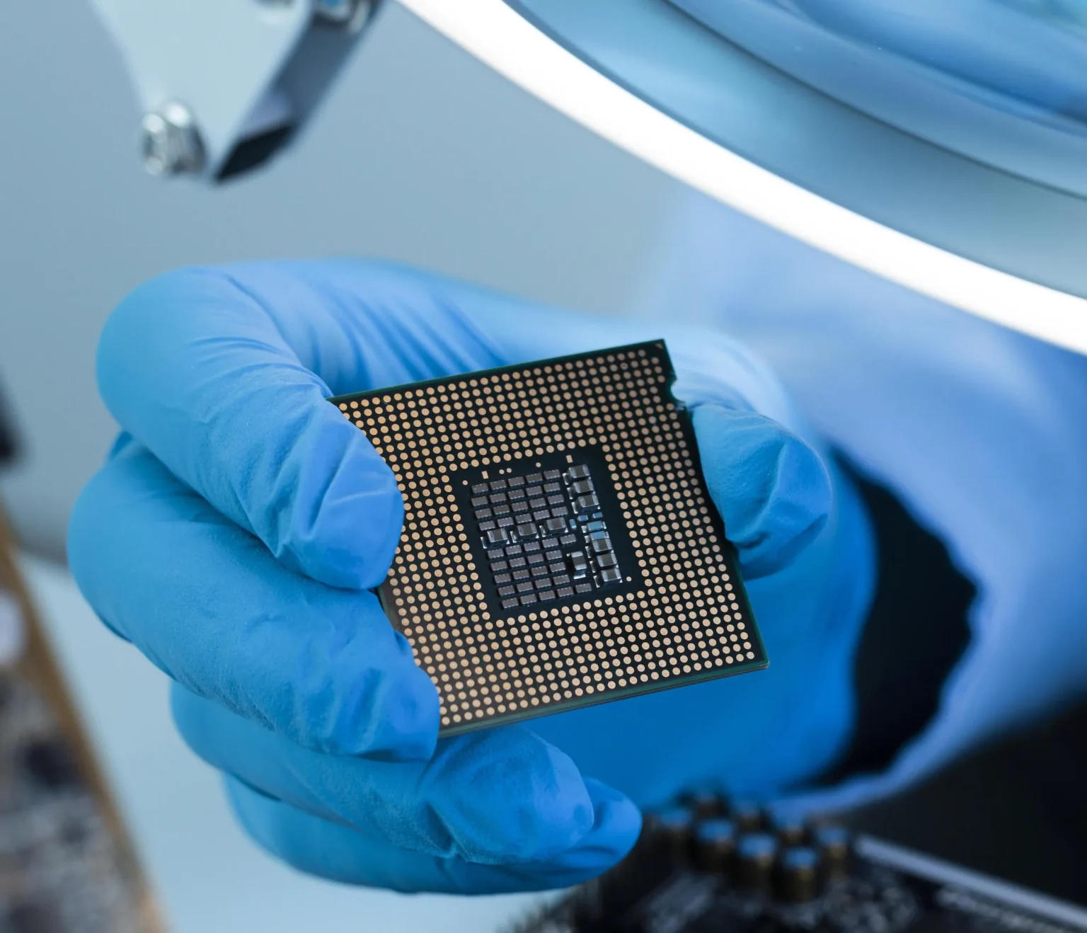 A gloved hand holding a microchip